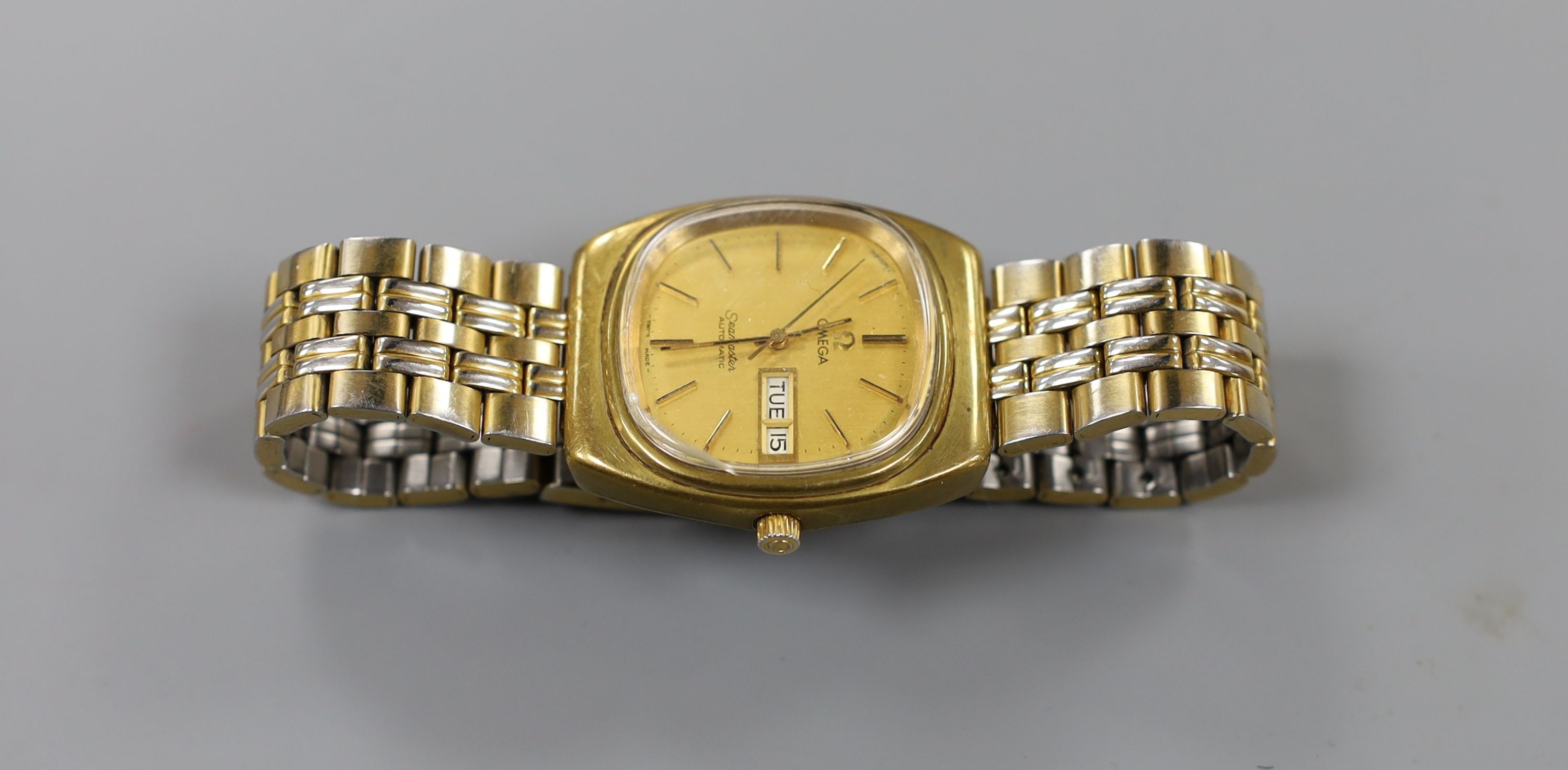 A gentleman's steel and gold plated Omega Seamaster automatic day/date wrist watch, on associated bracelet, case diameter 35mm.